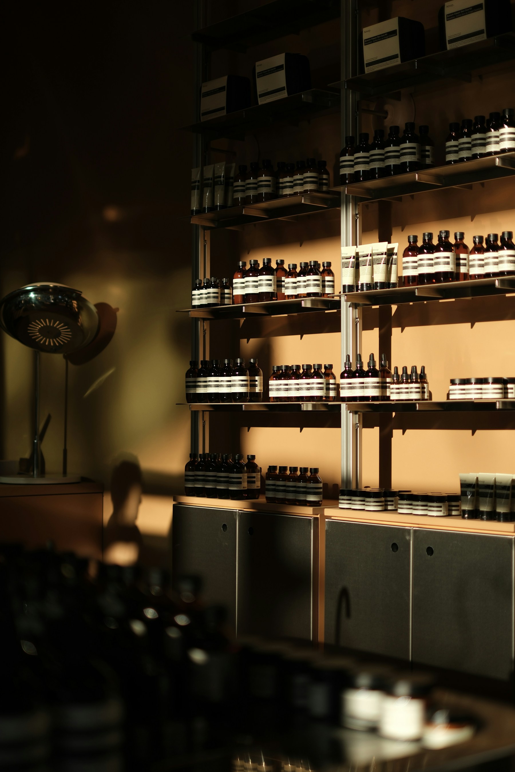 Amber skincare bottles arranged on shelves in warm light